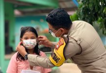 Kabut Asap Melanda Natuna, Bhabinkamtibmas Kelurahan Bandarsyah Ini Bagi Masker ke Anak-anak